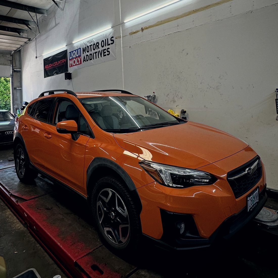 A performance car raised on a lift in the shop